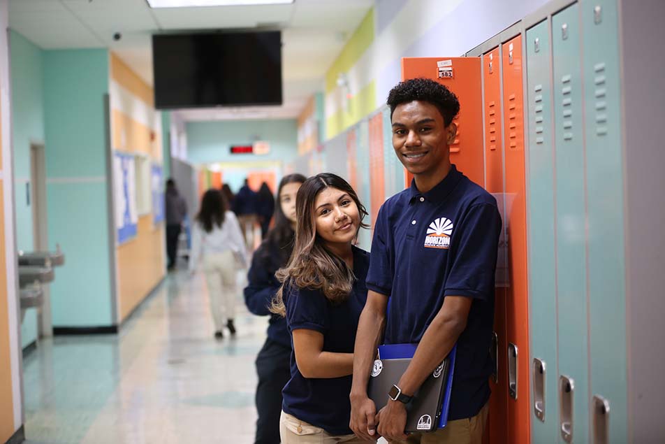 student in classroom smiling at camera